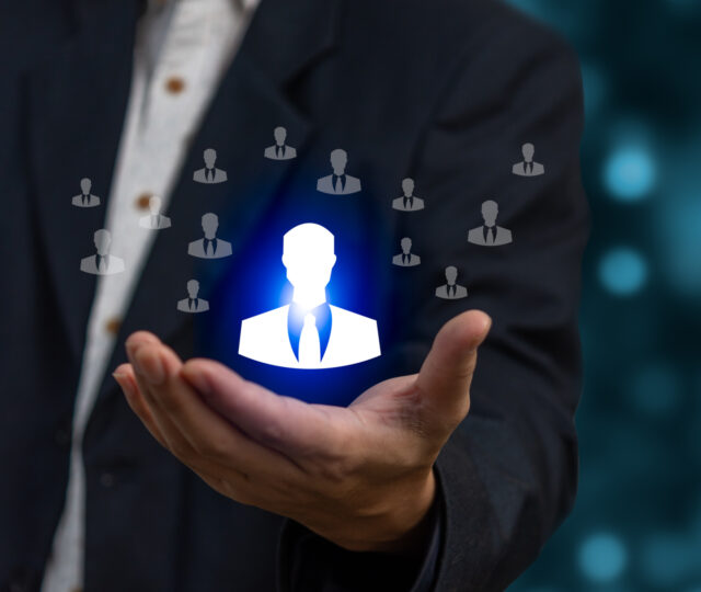 Businessman holding HRM or Human Resource Management, cons for human development recruitment leadership and customer target. Organization structure concept.